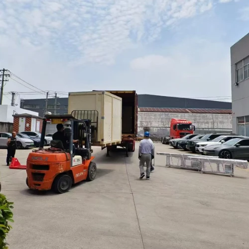 Forklift moving HAIFEI automated welding equipment to a shipping container outside the factory.